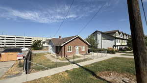 View of property exterior featuring a fenced front yard and brick siding