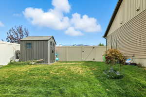 Fenced backyard with a gate and a storage shed