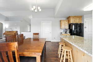 Dining room featuring dark wood-style flooring and a chandelier