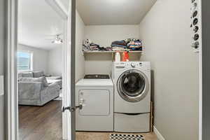 Washroom with a textured ceiling, ceiling fan, independent washer and dryer, and wood finished floors