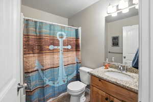 Full bath featuring vanity, light tile patterned floors, a textured ceiling, and a shower with shower curtain