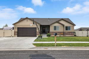 View of front of home featuring a gate, brick siding, an attached garage, and concrete driveway