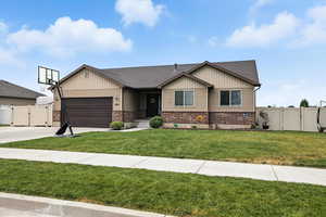 View of front of property with a gate, brick siding, an attached garage, driveway, and a shingled roof