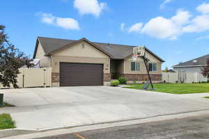 Craftsman inspired home with a gate, brick siding, and a garage