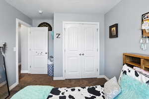 Bedroom featuring dark carpet, a closet, and a textured ceiling