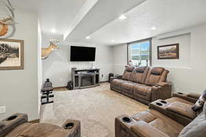 Living area featuring carpet floors, a textured ceiling, and recessed lighting
