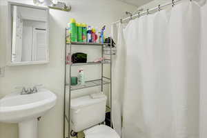 Full bath featuring toilet and curtained shower
