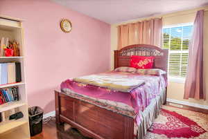 Bedroom with dark wood-style flooring