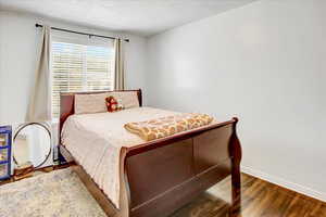 Bedroom with wood finished floors and baseboards