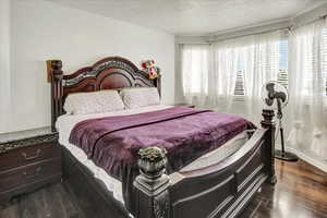 Bedroom featuring dark wood-style floors and a textured ceiling