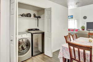 Laundry area featuring light wood-style flooring and washing machine and dryer