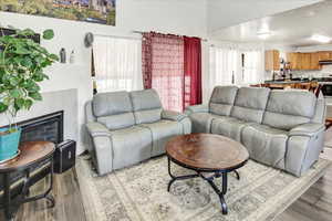 Living room with wood finished floors and a tiled fireplace