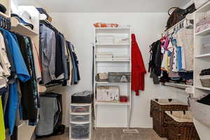 Spacious closet with dark carpet