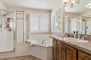 Full bath with a shower stall, vanity, a bath, and light tile patterned flooring