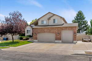 Traditional-style home featuring concrete driveway, brick siding, and a garage