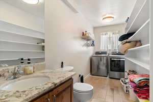 Bathroom featuring vanity, separate washer and dryer, and light wood-style flooring