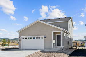 View of front facade with a mountain view, concrete driveway, and a garage