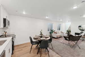 Dining space featuring stairway, light wood-style flooring, and recessed lighting