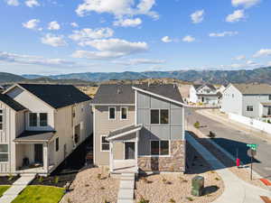 View of front of home featuring a mountain view, stone siding, and a residential view