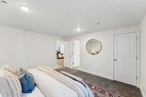 Carpeted bedroom featuring baseboards and a textured ceiling