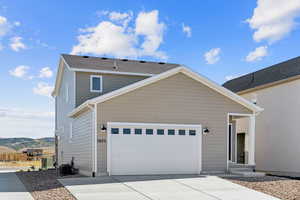 View of side of property with driveway, an attached garage, and a mountain view
