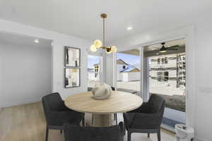 Dining area with light wood-style floors, a chandelier, recessed lighting, and covered patio
