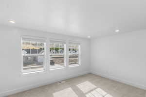Living room with light carpet, plenty of natural light, and recessed lighting