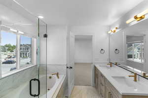 Primary Bathroom featuring double vanity, a bath, and recessed lighting
