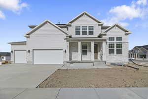 Craftsman inspired home featuring a porch, stone siding, driveway, and a garage