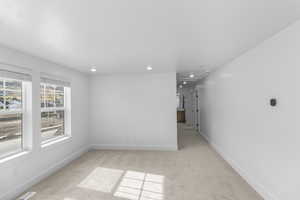 Living room with light colored carpet and recessed lighting