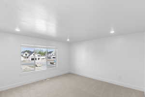 Primary Bedroom with light carpet and recessed lighting
