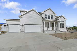 Craftsman-style home with stone siding, a porch, concrete driveway, and a garage