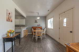 Dining room featuring a textured ceiling and dark wood-type flooring