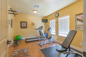 Workout area with wood finished floors and a textured ceiling