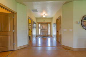 Entryway featuring a textured ceiling and baseboards