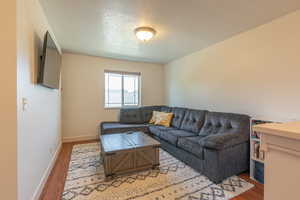 Living room with a textured ceiling and wood finished floors