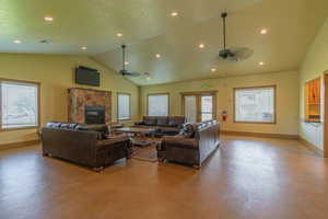 Living room with healthy amount of natural light, finished concrete flooring, a fireplace, recessed lighting, and a ceiling fan