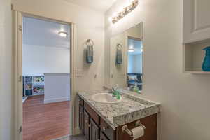 Half bath with vanity, wood finished floors, and a textured ceiling