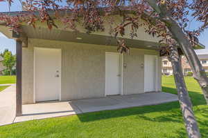 Entrance to property with a lawn and stucco siding