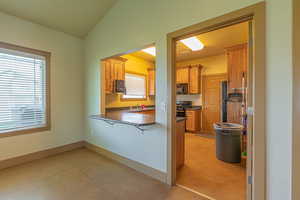 Kitchen featuring dark countertops, a breakfast bar, light floors, stove, and black microwave