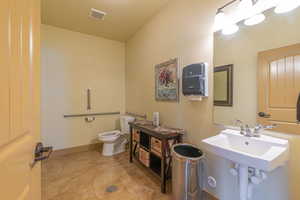 Half bathroom with toilet and light tile patterned floors