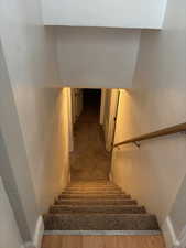 Staircase with a textured wall and wood finished floors