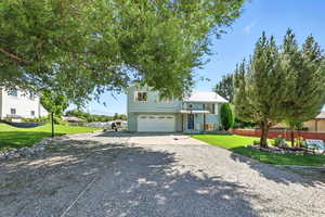 View of front of property with driveway, a garage, and a metal roof
