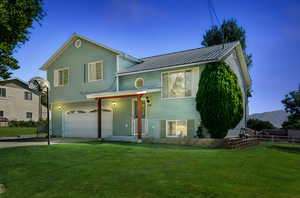 View of front of home with a garage, a metal roof, and concrete driveway
