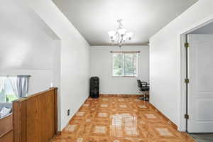 Spare room with a chandelier and light tile patterned flooring