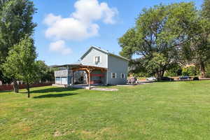 Back of house with a lawn and a wooden deck