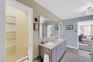 Bathroom featuring double vanity and light wood finished floors