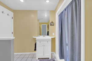 Bathroom featuring light tile patterned floors, vanity, recessed lighting, and curtained shower