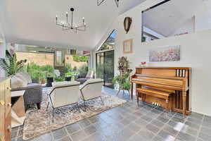 Sunroom / solarium featuring lofted ceiling and a chandelier