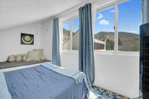 Bedroom featuring a mountain view and vaulted ceiling